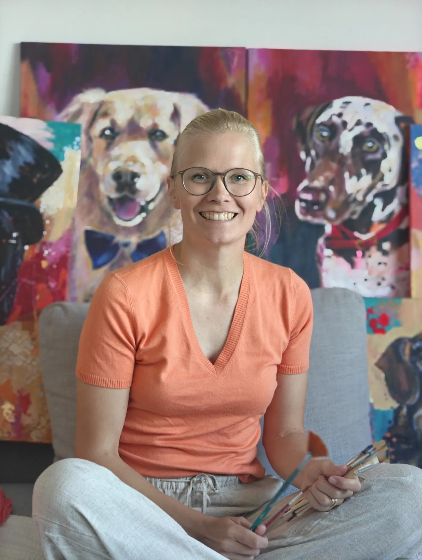 Emma-Sofia seated with her paintings